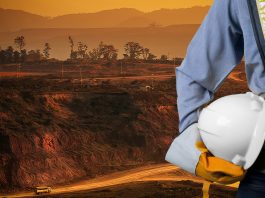 Engineer holding a white helmet for the safety of mining workers