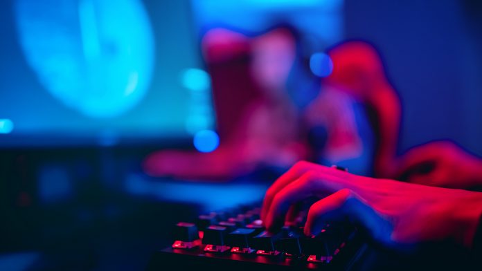 Blurred,Background,Computer,,Keyboard,,Blue,And,Red,Teams,Lights,Concept,Esports