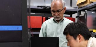 Lead muon detector developer Polad Shikhaliev looks on as JungHyun Bae, a Wigner Distinguished Staff Fellow at ORNL, looks inside a muon detector he envisioned during his doctoral studies. Credit: Sumner Brown Gibbs/ORNL, U.S. Dept. of Energy